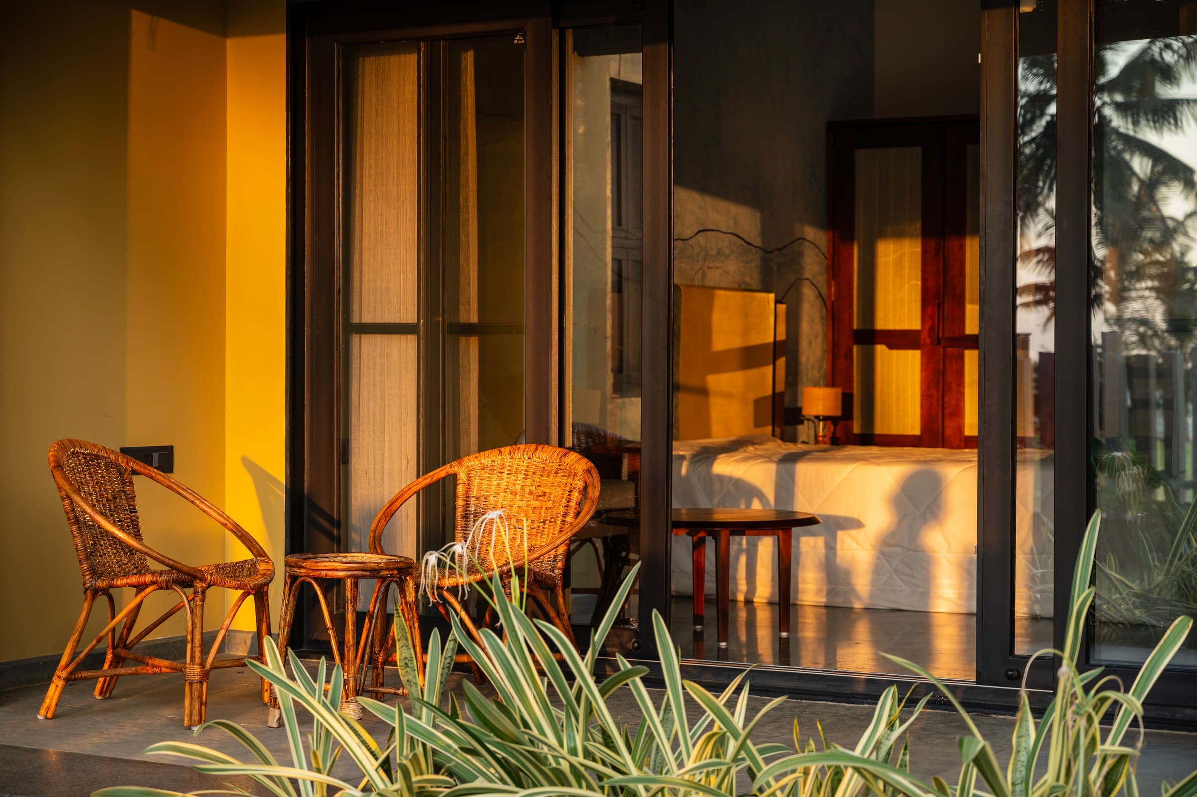 A ground-floor patio with cane chairs in golden evening light