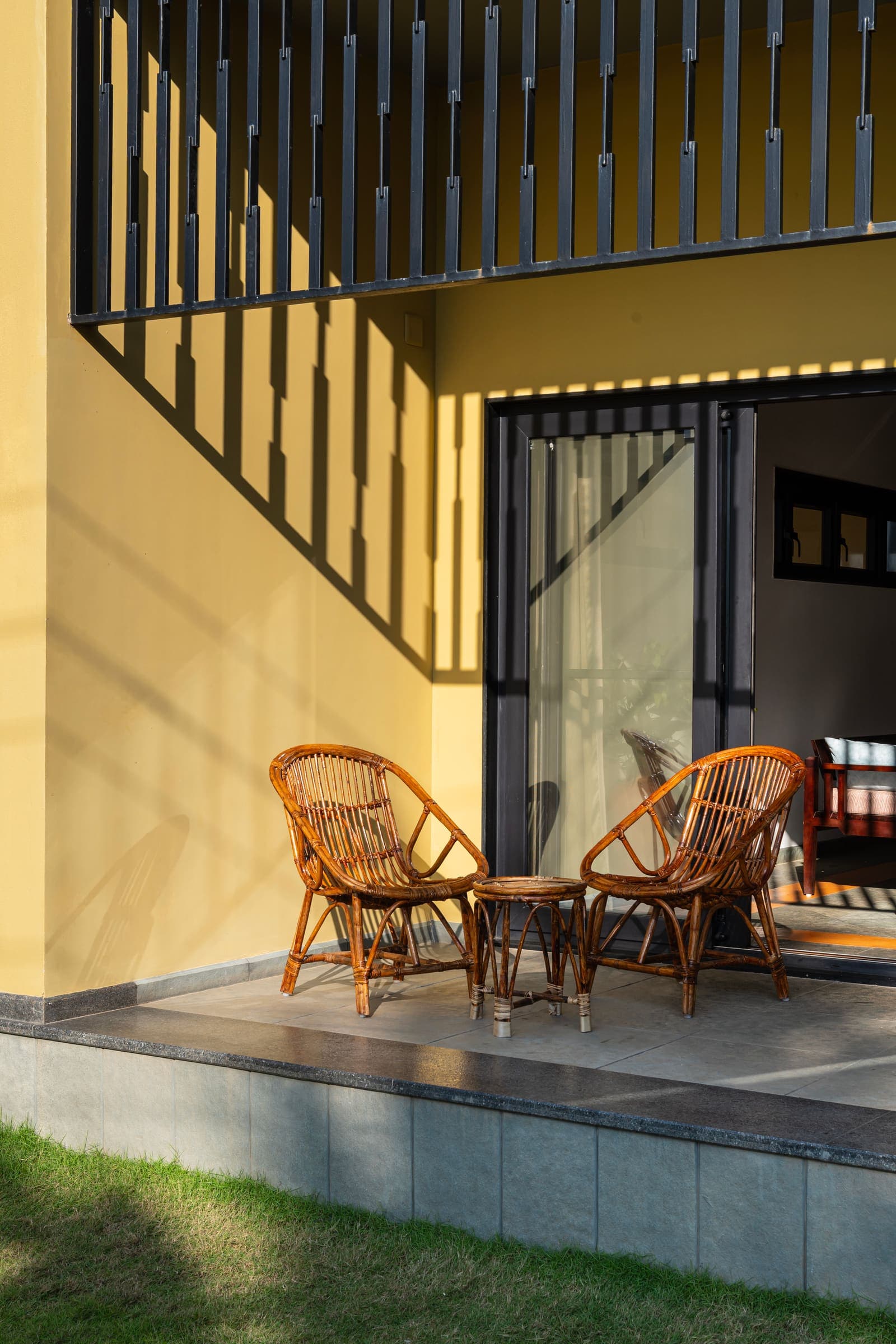 A sea-facing patio with cane chairs