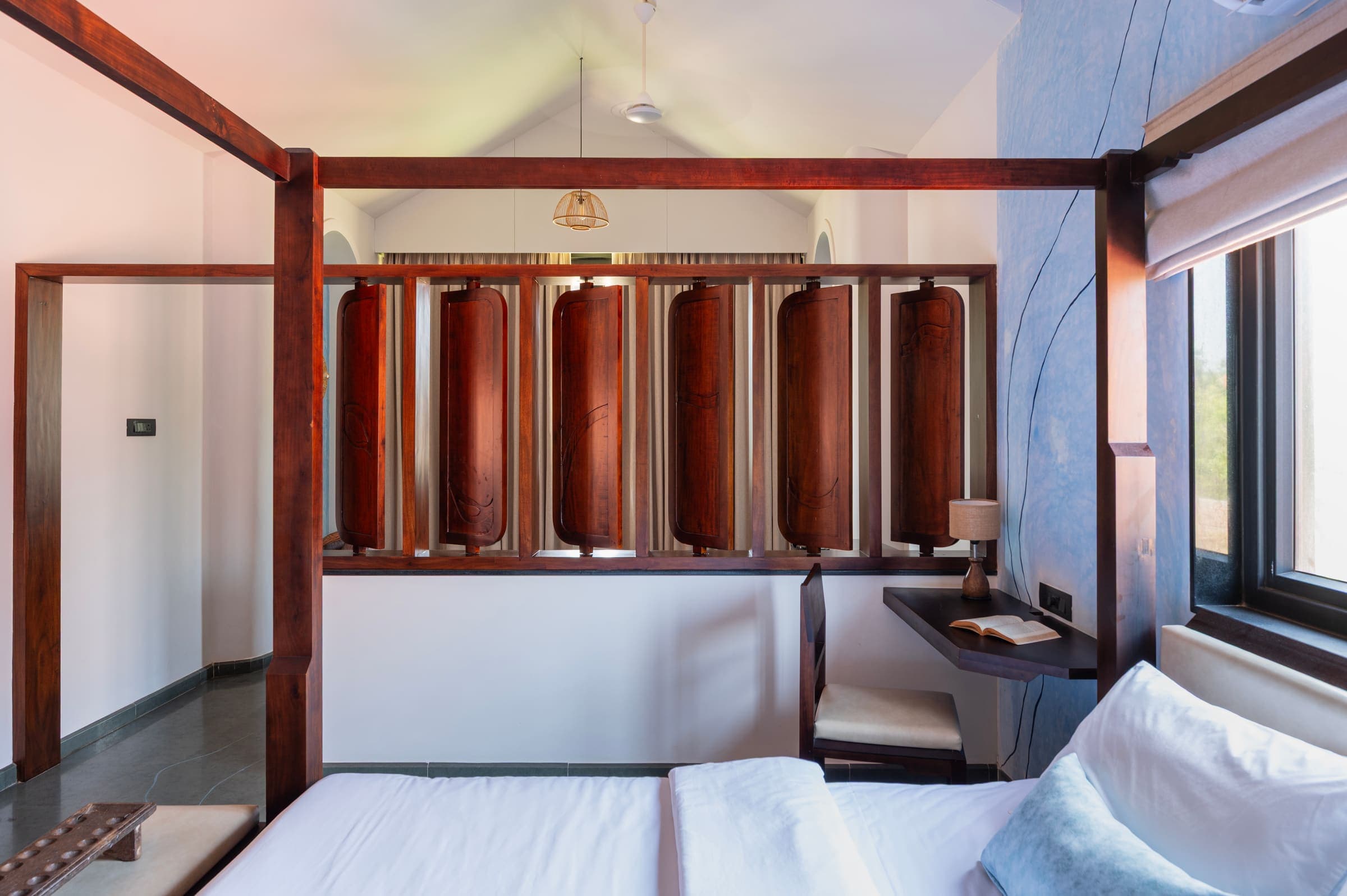 The Varahi four-poster bed and carved wooden divider under the vaulted ceiling