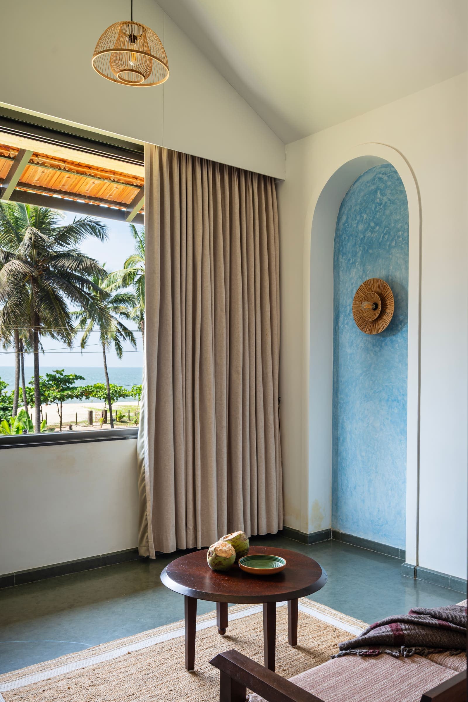 The Varahi seating corner with a view of coconut palms and the sea